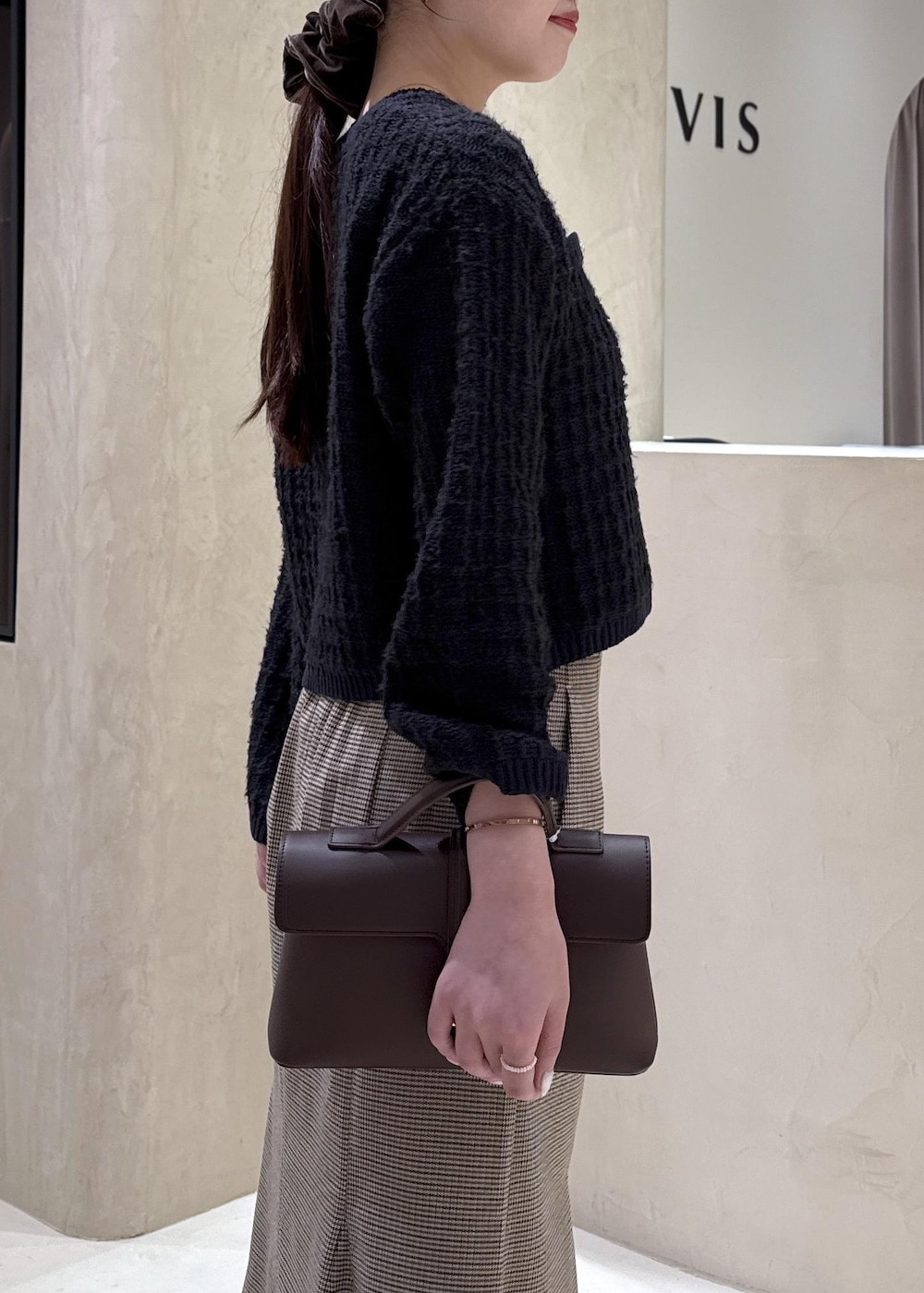 ブラウン系のショルダーバッグ、イエロー系のパンプス、ベージュ系のスカートを着用したレディースの秋コーディネートの4枚目の写真