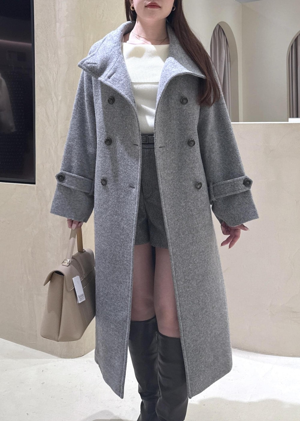 ベージュ系のハンドバッグ、ホワイト系のニット/セーター、グレー系のその他アウターを着用したレディースの秋コーディネートの3枚目の写真