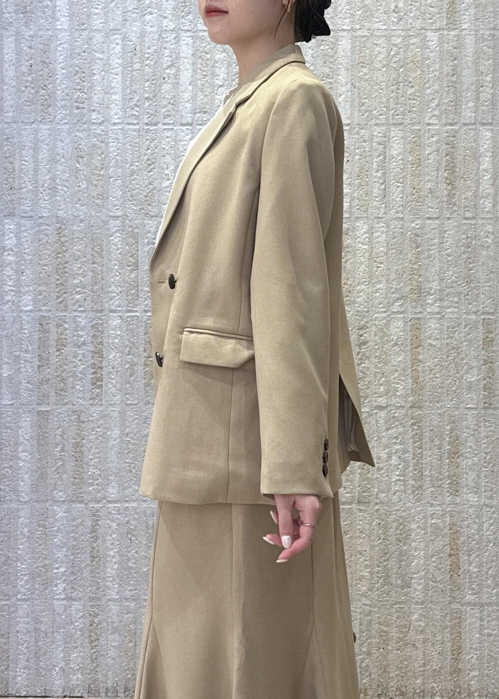 ブラウン系のハンドバッグ、イエロー系のパンプス、ベージュ系のスカートを着用したレディースの秋コーディネートの7枚目の写真