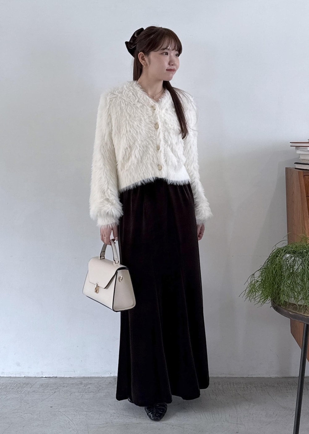 ホワイト系のキャミソール、ブラック系のパンプス、ブラック系のスカートを着用したレディースの秋コーディネートの2枚目の写真