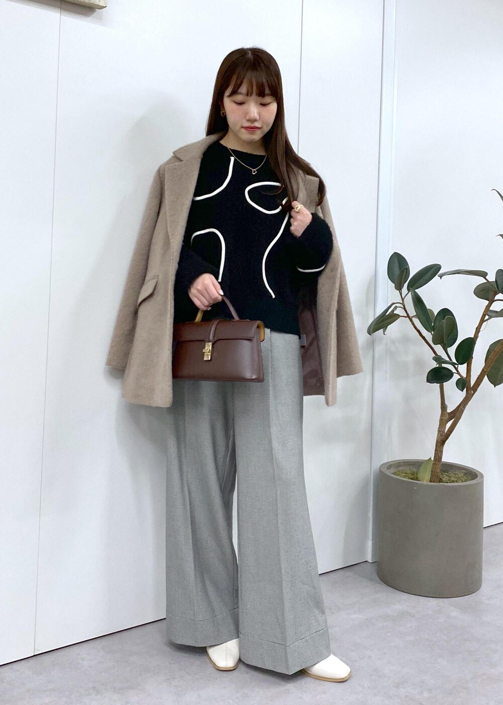 ホワイト系のブーツ、ブラック系のニット/セーター、ブラウン系のその他アウターを着用したレディースの秋コーディネートの3枚目の写真