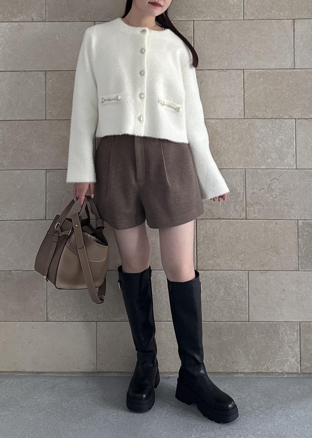 ブラック系のブーツ、ブラウン系のその他パンツ、ホワイト系のカーディガン/ボレロを着用したレディースの秋コーディネートの2枚目の写真