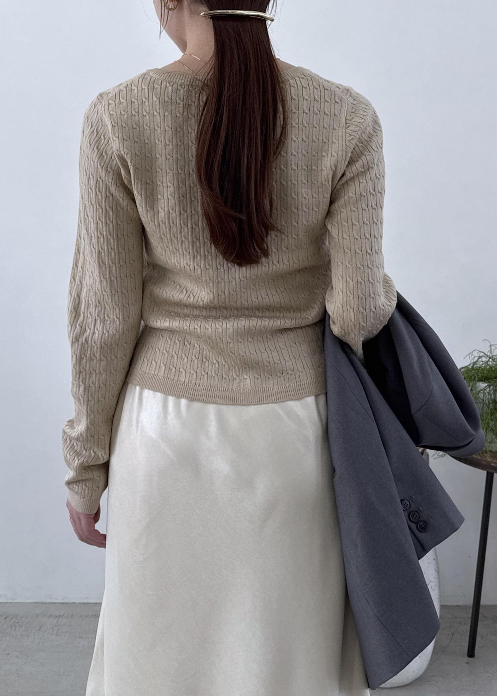 グレー系のテーラードジャケット、ブラック系のブーツ、ホワイト系のスカートを着用したレディースの秋コーディネートの7枚目の写真