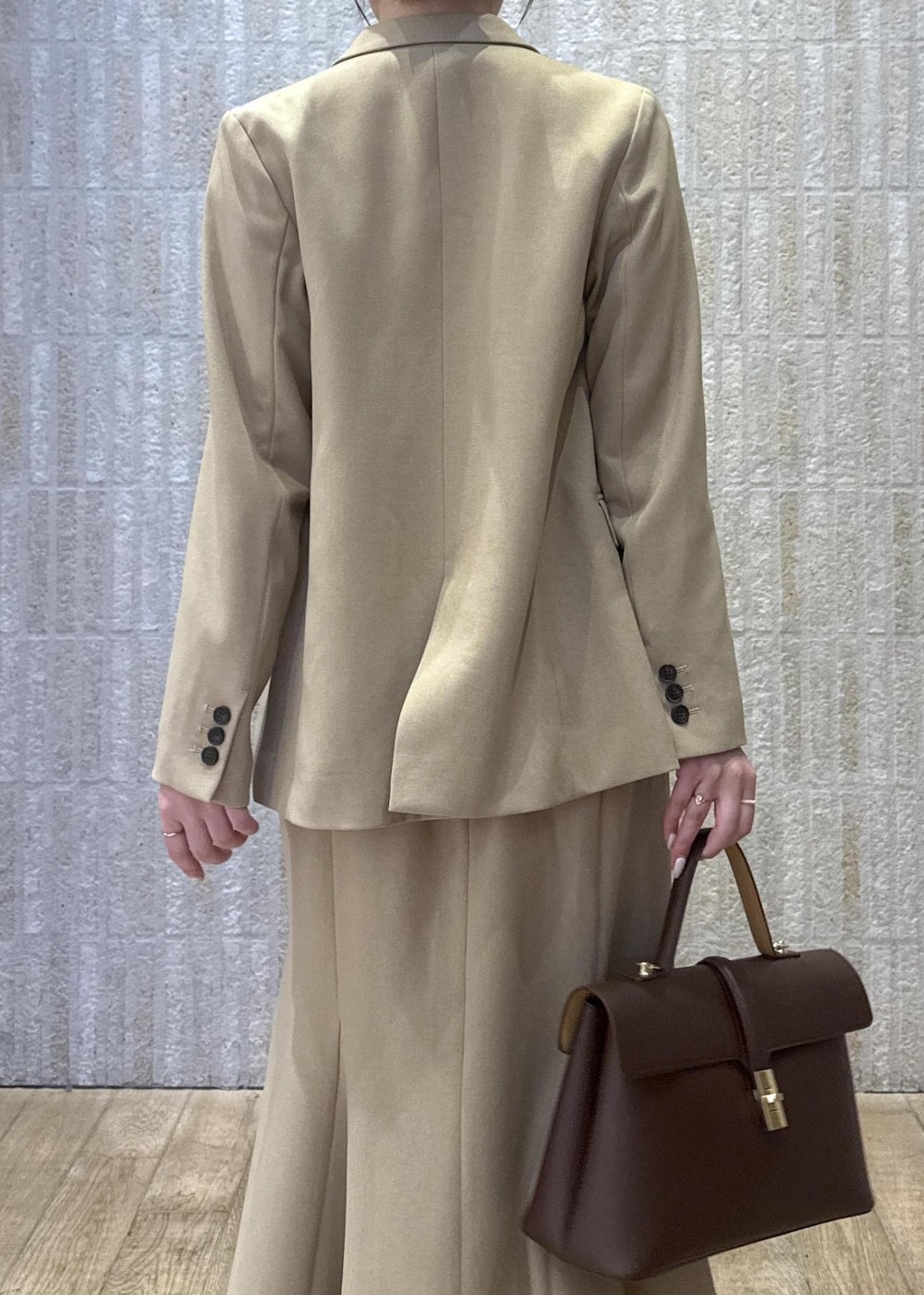 ブラウン系のハンドバッグ、イエロー系のパンプス、ベージュ系のスカートを着用したレディースの秋コーディネートの8枚目の写真