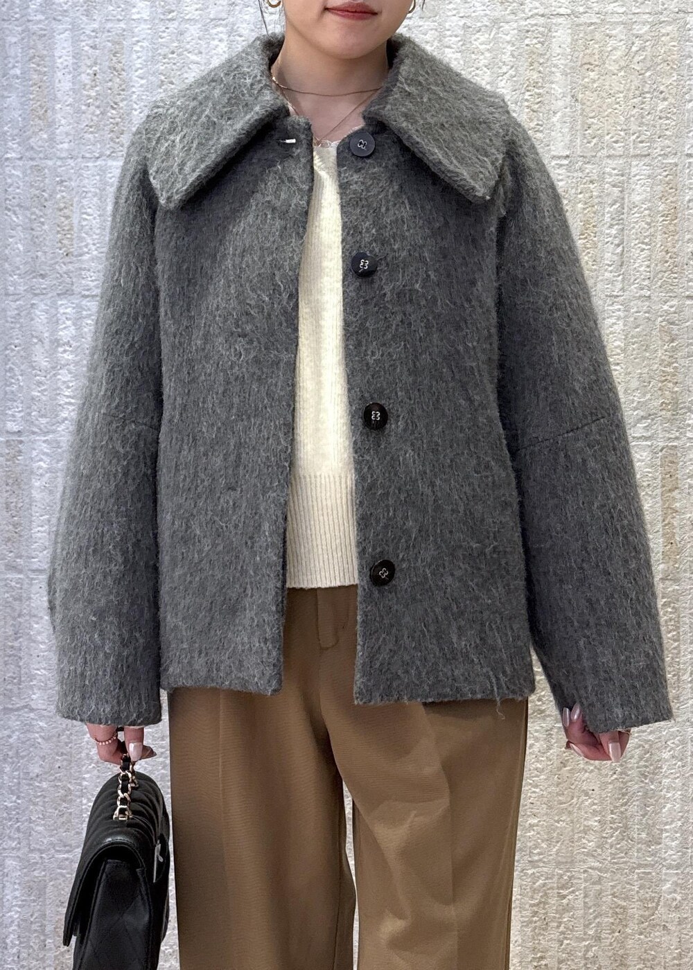 グレー系のブルゾン、ホワイト系のニット/セーター、イエロー系のその他パンツを着用したレディースの冬コーディネートの4枚目の写真