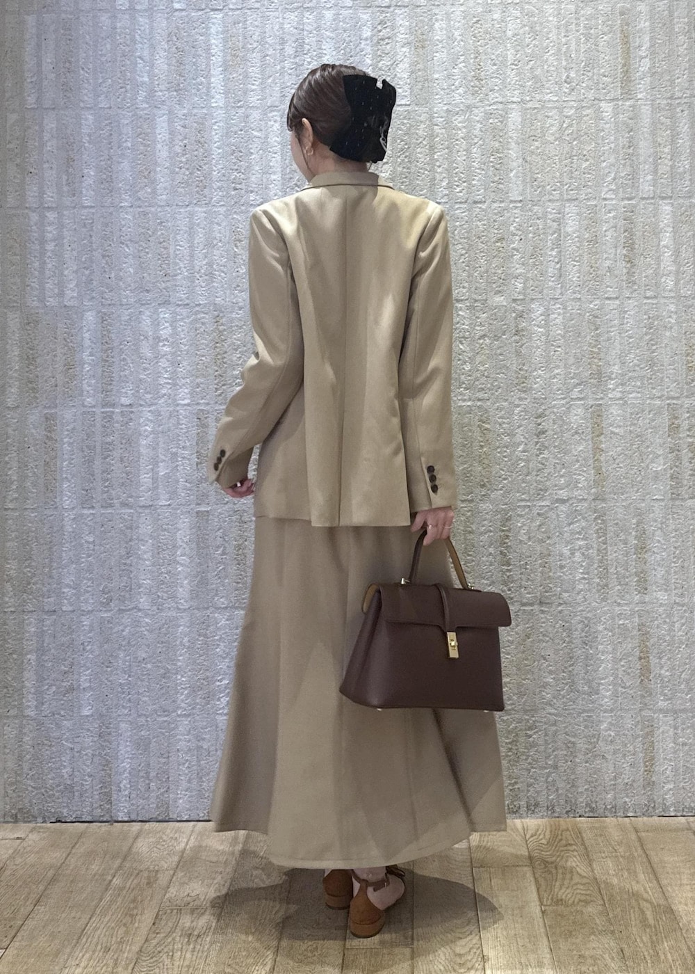 ブラウン系のハンドバッグ、イエロー系のパンプス、ベージュ系のスカートを着用したレディースの秋コーディネートの10枚目の写真