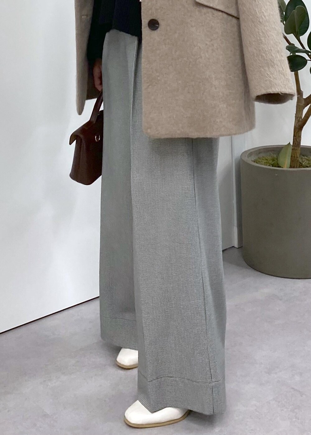 ホワイト系のブーツ、ブラック系のニット/セーター、ブラウン系のその他アウターを着用したレディースの秋コーディネートの6枚目の写真