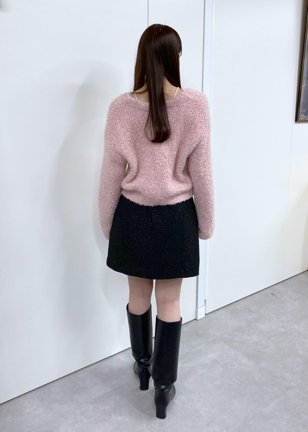 ホワイト系のキャミソール、ブラック系のブーツ、ブラック系のスカートを着用したレディースの冬コーディネートの6枚目の写真