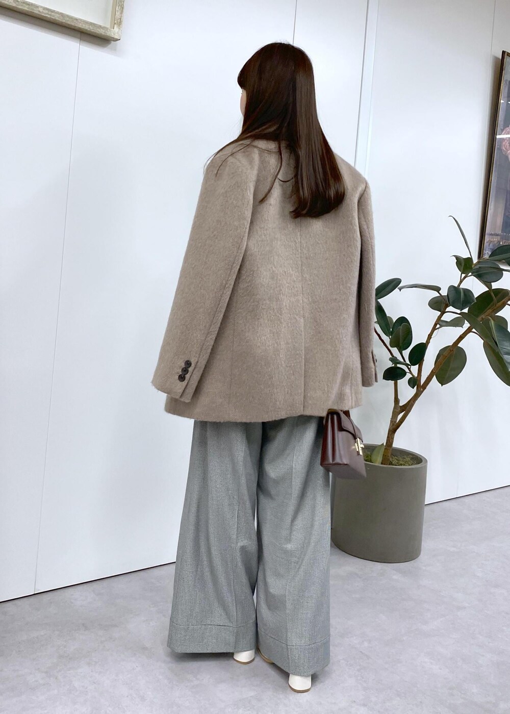 ホワイト系のブーツ、ブラック系のニット/セーター、ブラウン系のその他アウターを着用したレディースの秋コーディネートの8枚目の写真