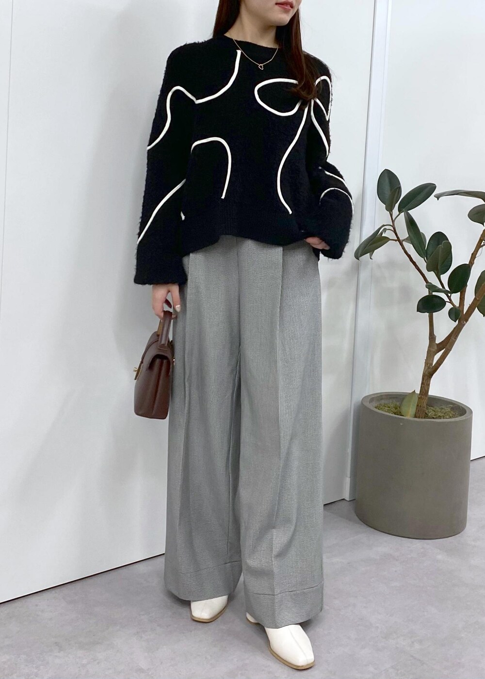 ホワイト系のブーツ、ブラック系のニット/セーター、ブラウン系のその他アウターを着用したレディースの秋コーディネートの5枚目の写真