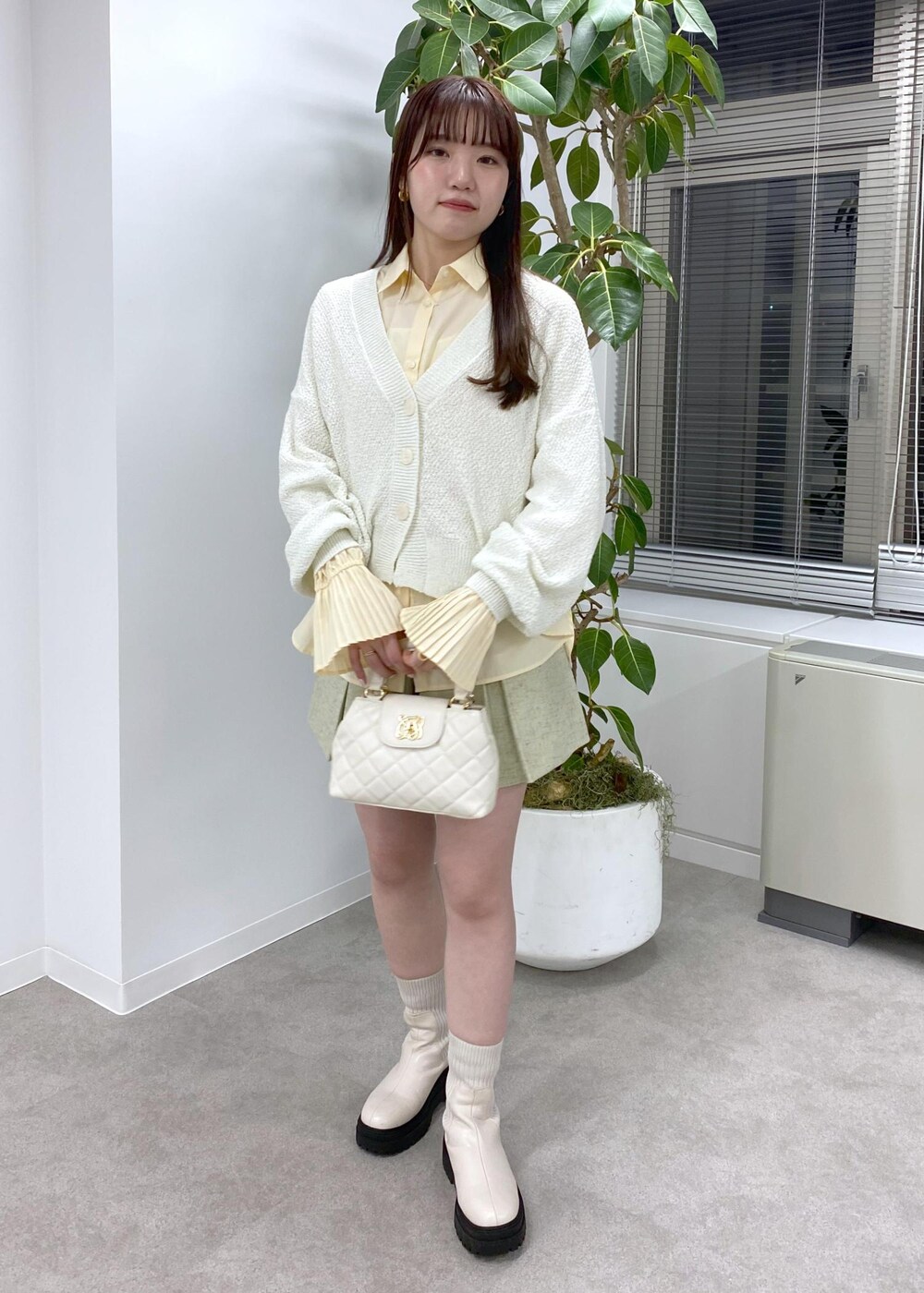 ホワイト系のブーツ、ホワイト系のカーディガン/ボレロ、ホワイト系のその他パンツを着用したレディースの冬コーディネートの3枚目の写真