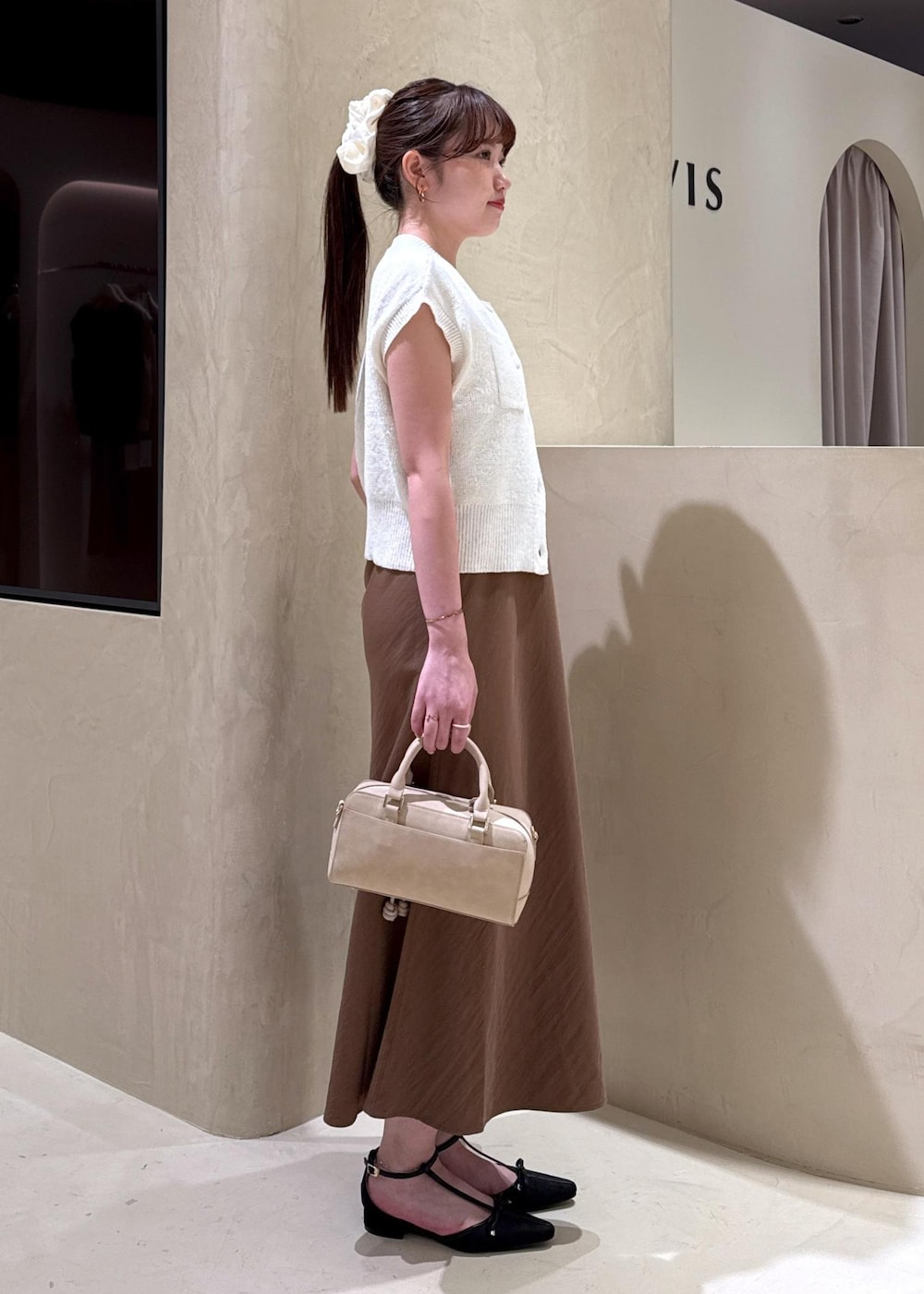 ホワイト系のキャミソール、ブラウン系のワンピース、ホワイト系のカーディガン/ボレロを着用したレディースの夏コーディネートの5枚目の写真