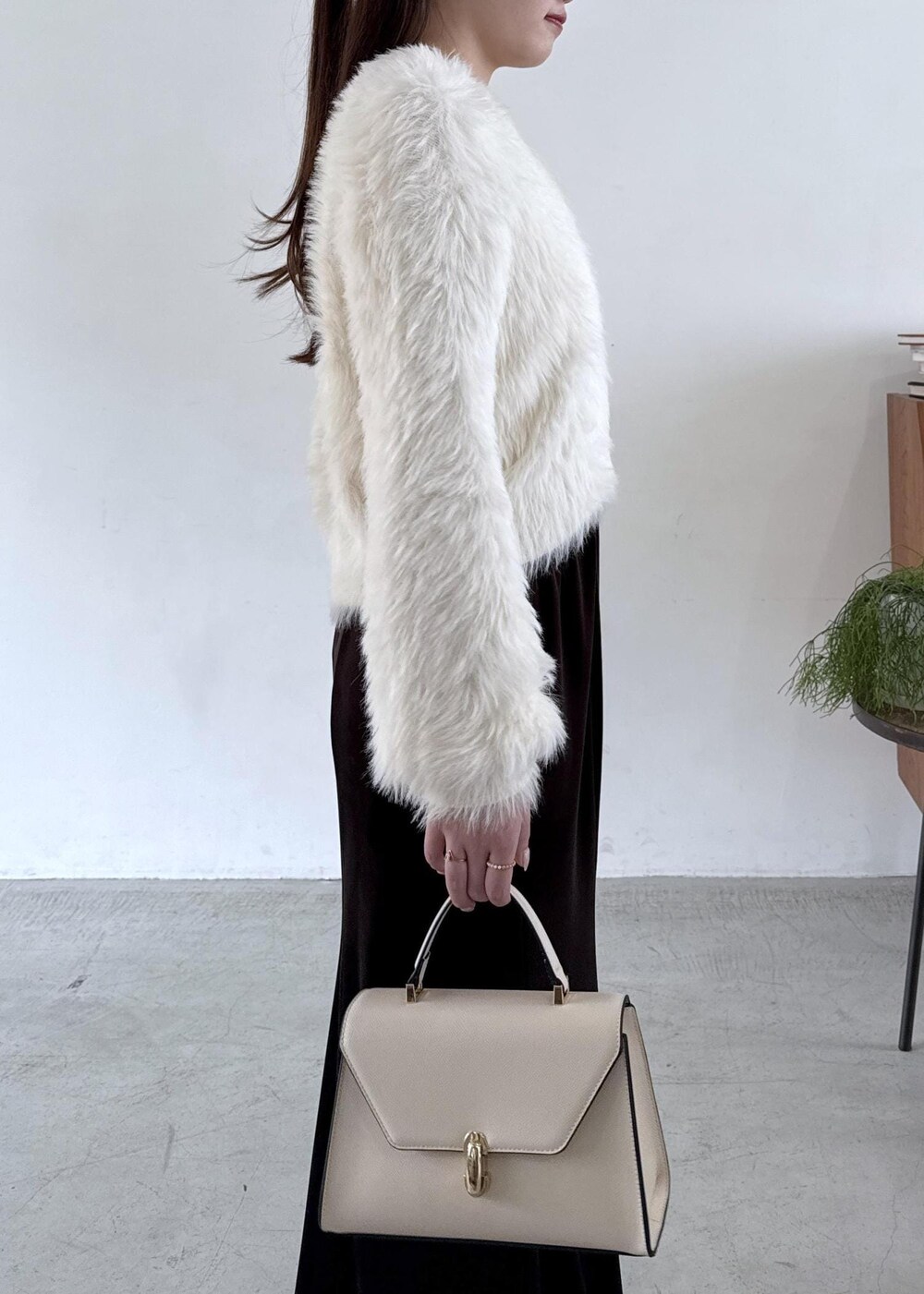 ホワイト系のキャミソール、ブラック系のパンプス、ブラック系のスカートを着用したレディースの秋コーディネートの4枚目の写真