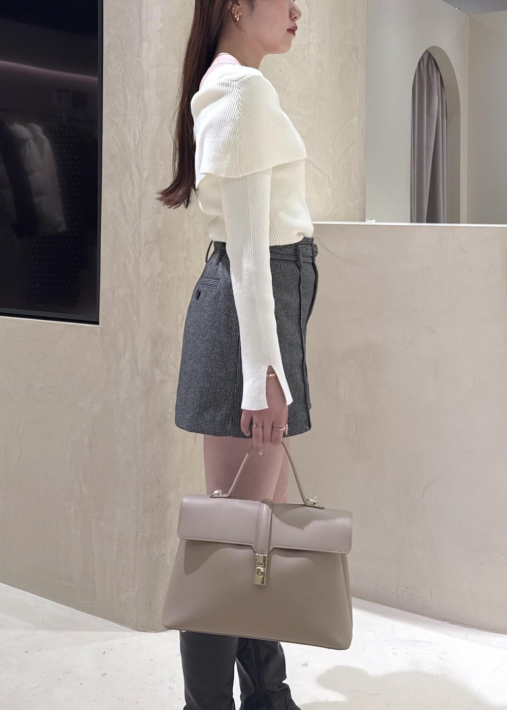 ベージュ系のハンドバッグ、ホワイト系のニット/セーター、グレー系のその他アウターを着用したレディースの秋コーディネートの5枚目の写真