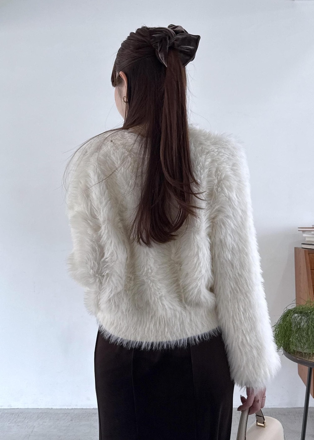 ホワイト系のキャミソール、ブラック系のパンプス、ブラック系のスカートを着用したレディースの秋コーディネートの6枚目の写真