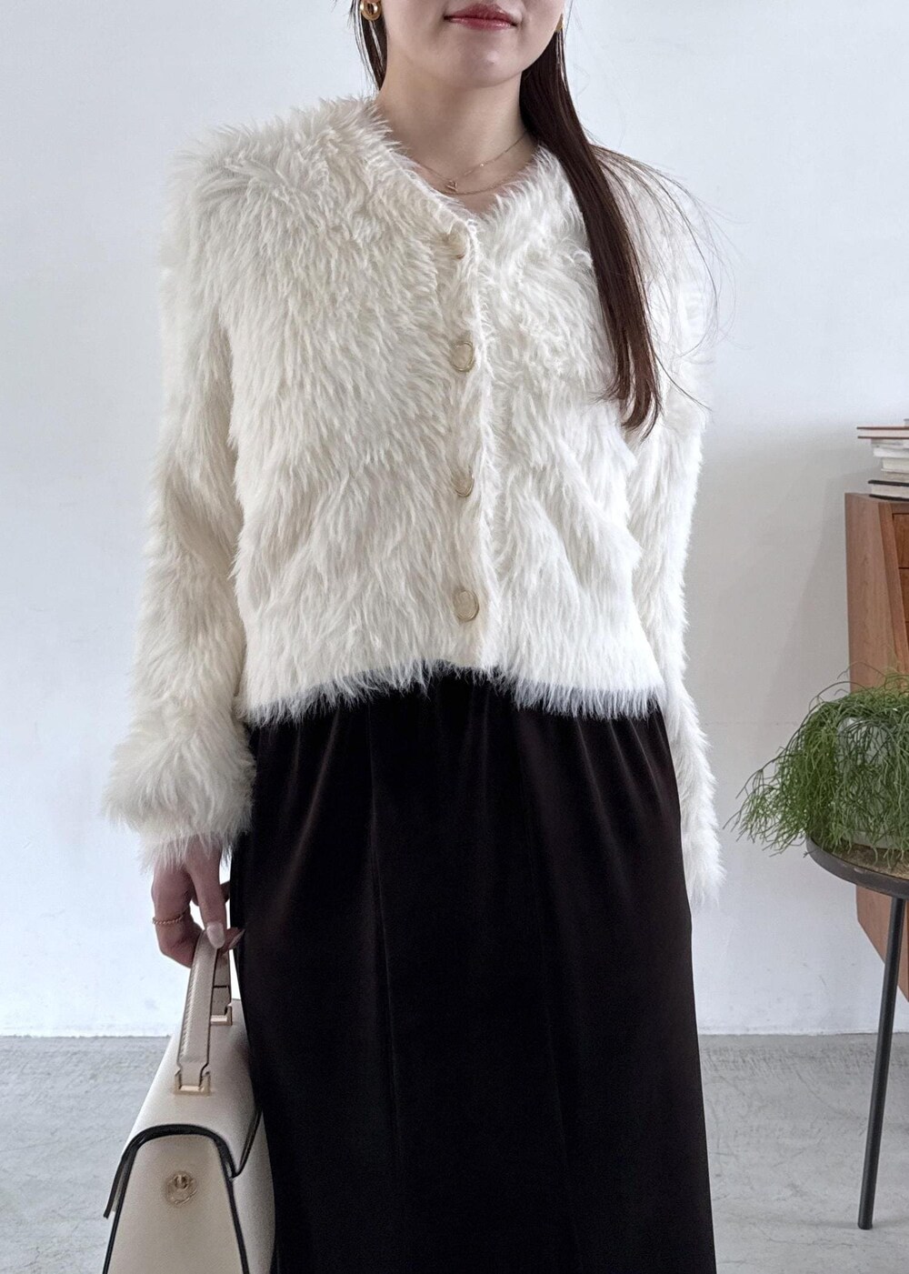 ホワイト系のキャミソール、ブラック系のパンプス、ブラック系のスカートを着用したレディースの秋コーディネートの3枚目の写真