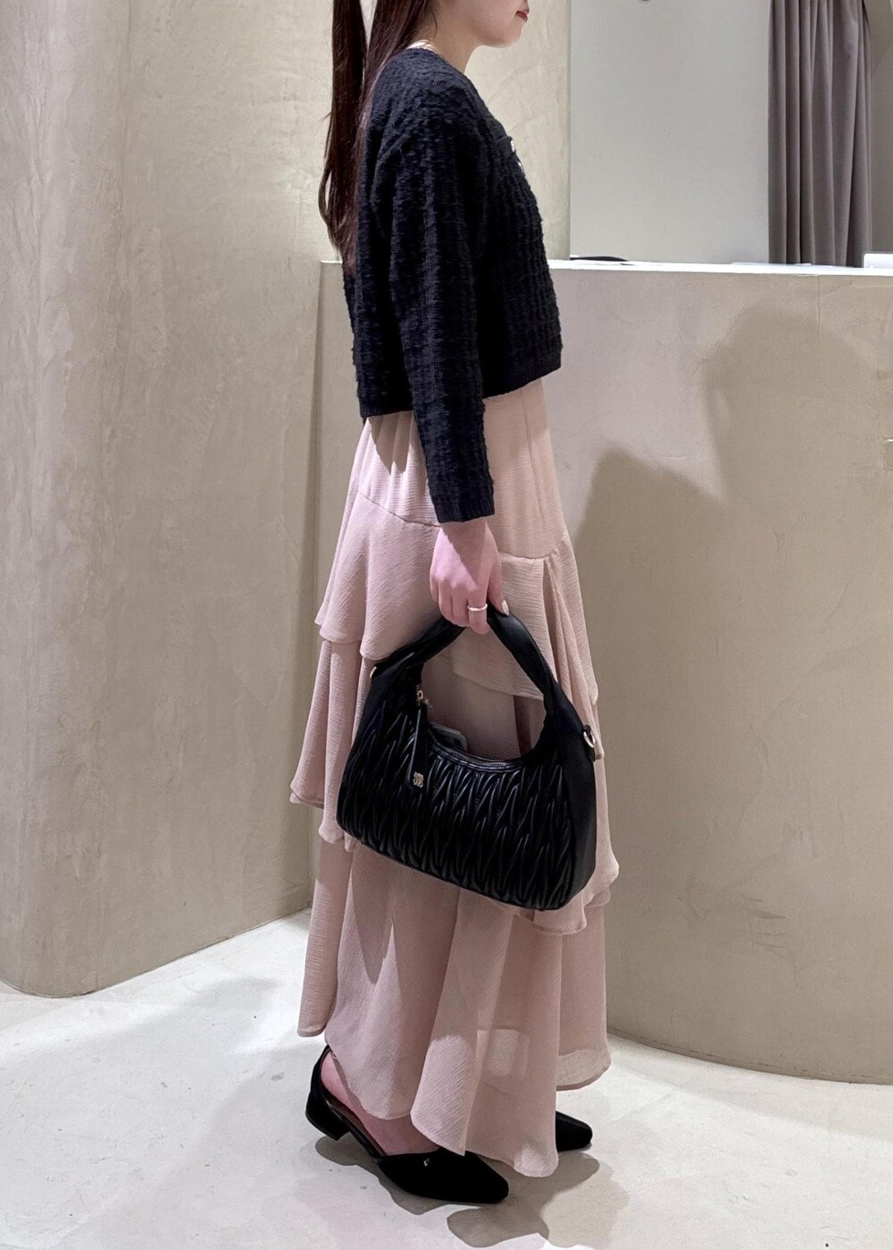 ホワイト系のキャミソール、ブラック系のパンプス、ブラック系のハンドバッグを着用したレディースの秋コーディネートの6枚目の写真