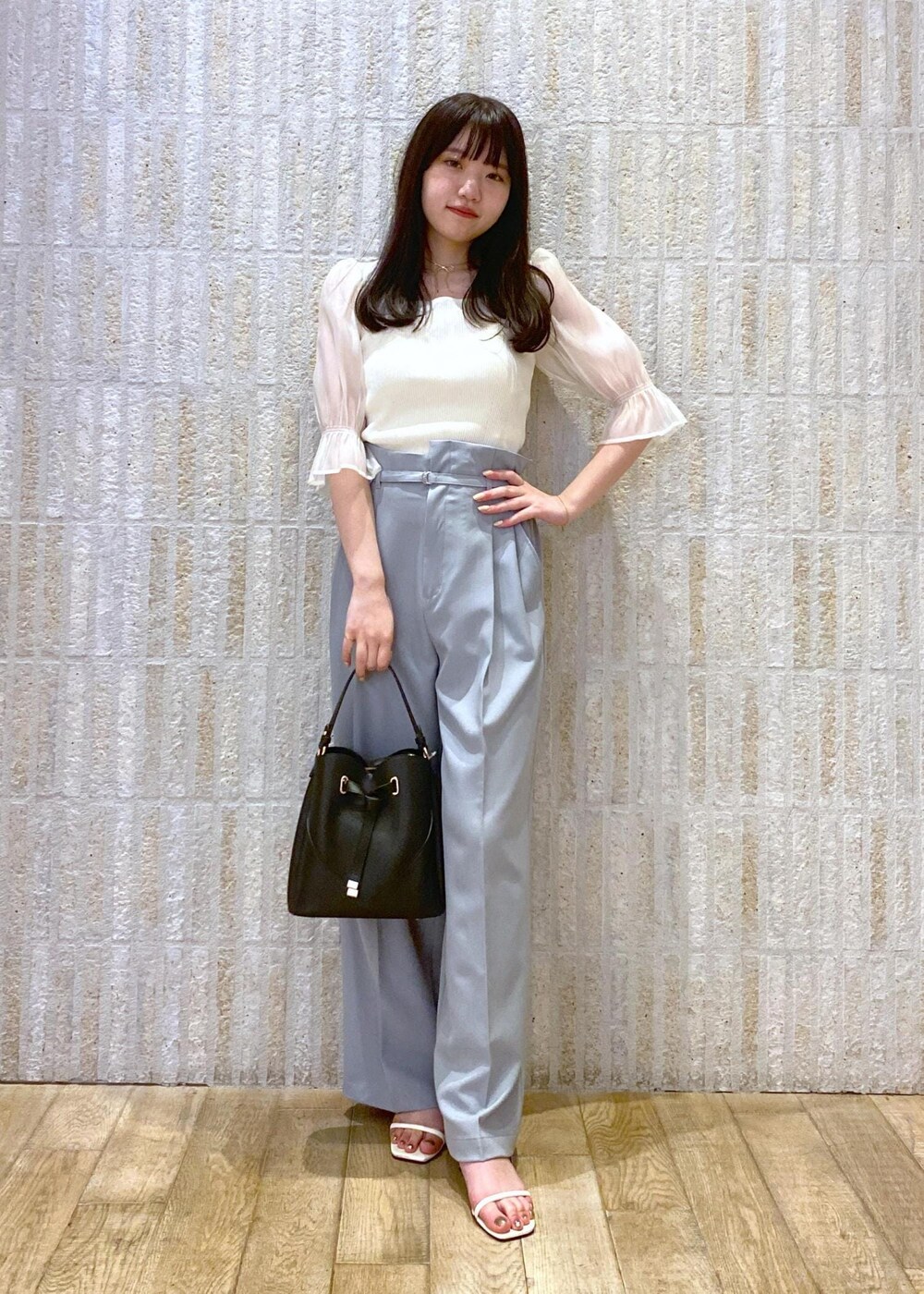 ホワイト系のサンダル、ブルー系のスラックス、ホワイト系のTシャツ/カットソーを着用したレディースの夏コーディネートの2枚目の写真