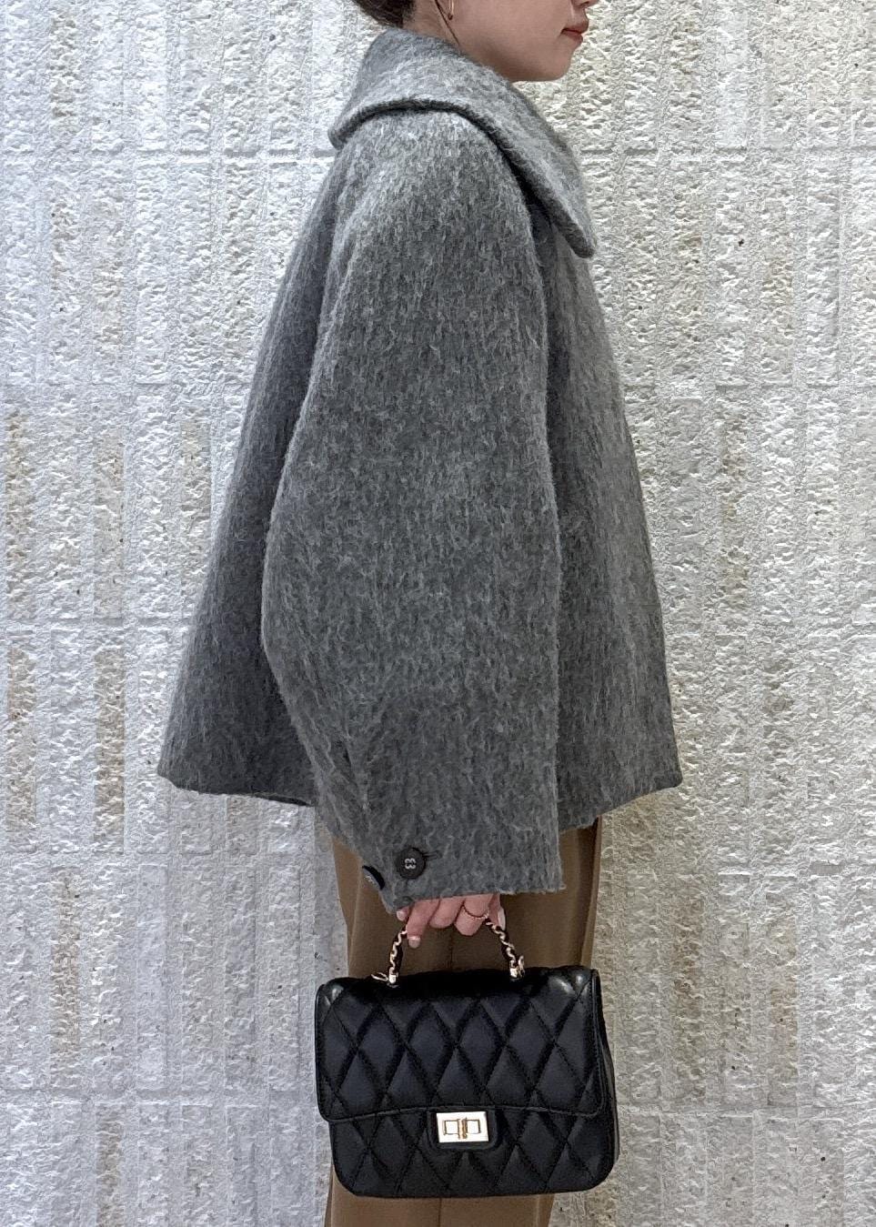 グレー系のブルゾン、ホワイト系のニット/セーター、イエロー系のその他パンツを着用したレディースの冬コーディネートの6枚目の写真