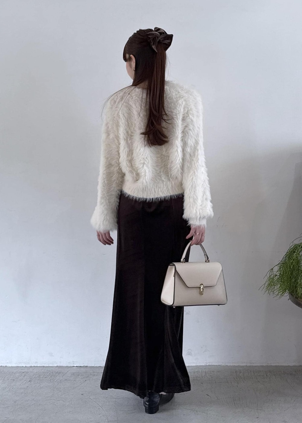 ホワイト系のキャミソール、ブラック系のパンプス、ブラック系のスカートを着用したレディースの秋コーディネートの7枚目の写真