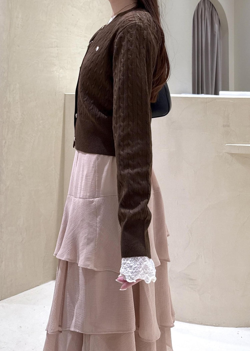 ブラック系のパンプス、ピンク系のスカート、ブラウン系のカーディガン/ボレロを着用したレディースの秋コーディネートの4枚目の写真