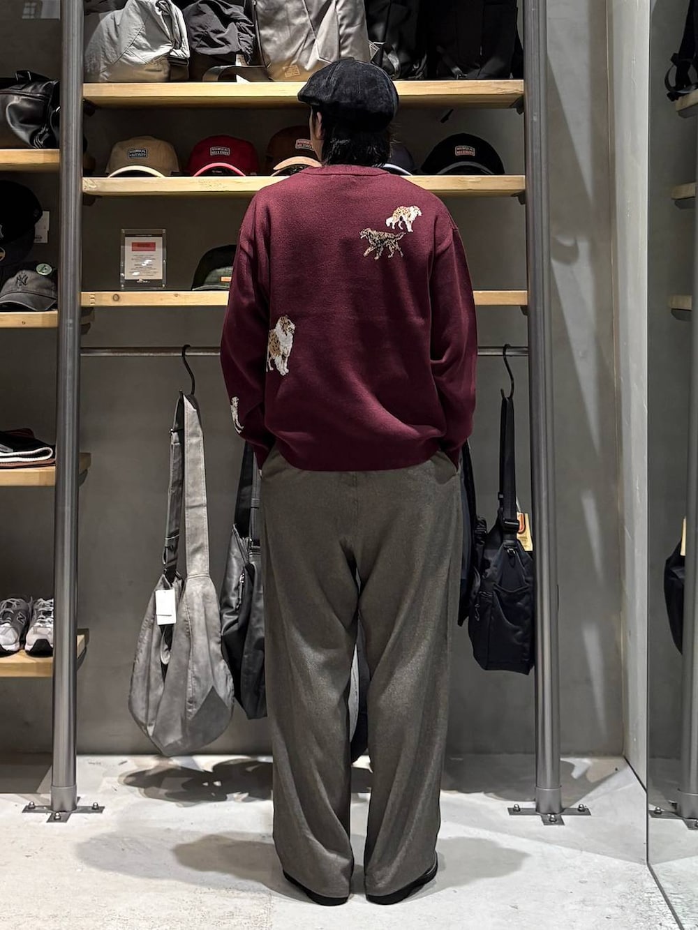 レッド系のニット/セーター、ベージュ系のその他パンツ、ブラック系のローファーを着用したメンズの秋コーディネートの3枚目の写真