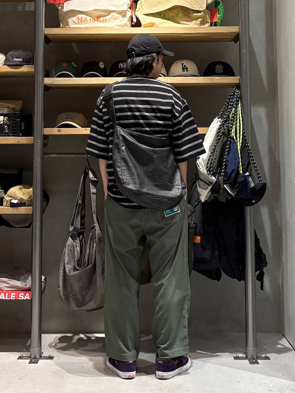 ブラック系のショルダーバッグ、ブラック系のTシャツ/カットソー、グリーン系のその他パンツを着用したメンズの夏コーディネートの3枚目の写真