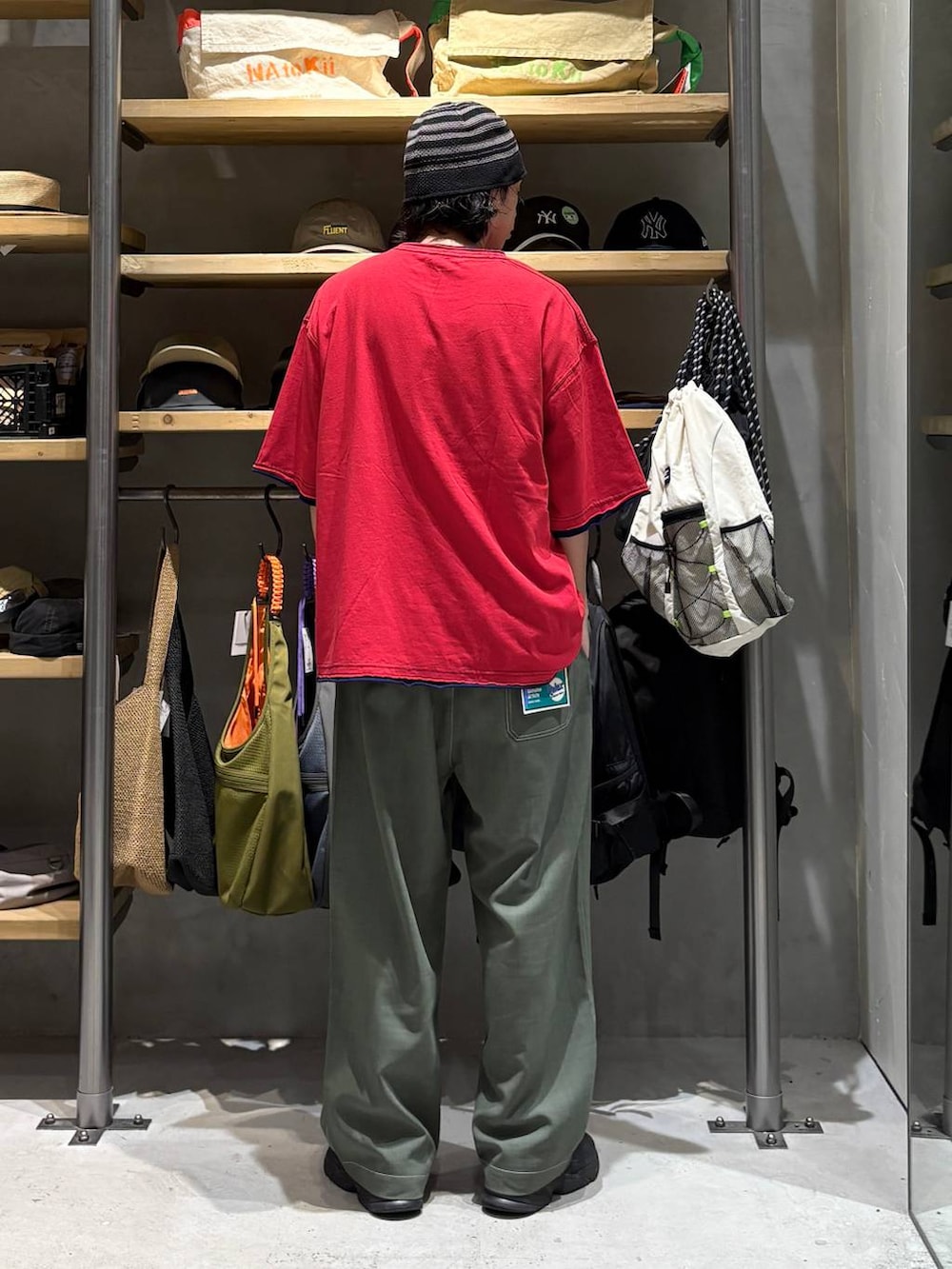グリーン系のその他パンツ、レッド系のTシャツ/カットソー、ブラック系のハットを着用したメンズの夏コーディネートの3枚目の写真