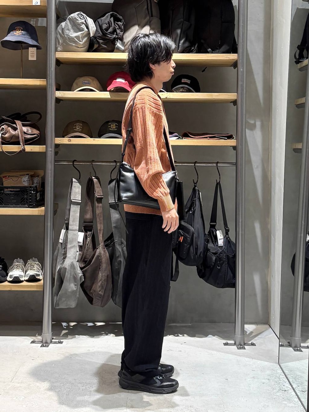 ブラック系のその他パンツ、オレンジ系のニット/セーターを着用したメンズの秋コーディネートの2枚目の写真