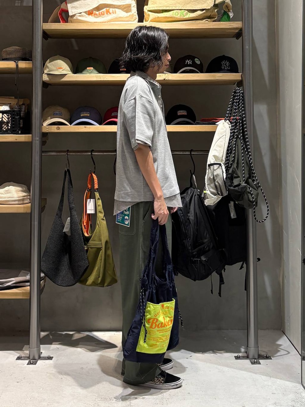 ブルー系のトートバッグ、グリーン系のその他パンツ、グレー系のポロシャツを着用したメンズの夏コーディネートの2枚目の写真