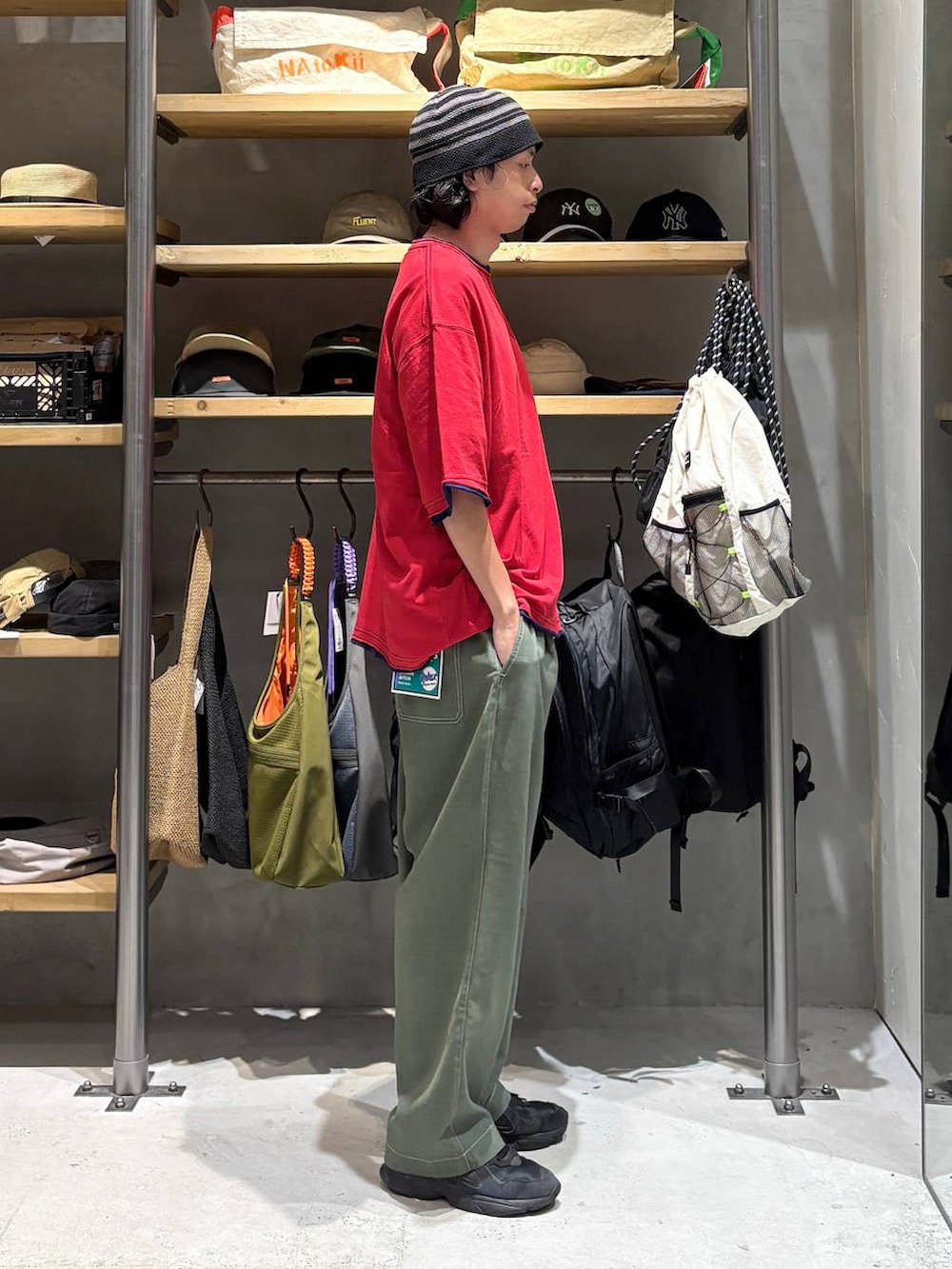 グリーン系のその他パンツ、レッド系のTシャツ/カットソー、ブラック系のハットを着用したメンズの夏コーディネートの2枚目の写真