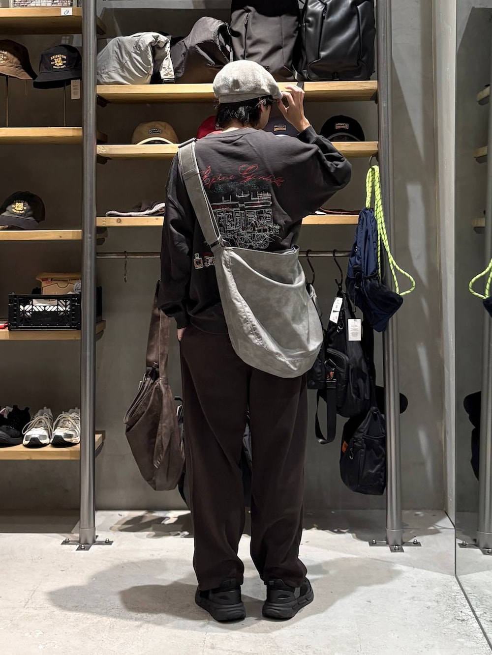 グレー系のショルダーバッグ、ブラウン系のスウェットパンツ、グレー系のスウェットを着用したメンズの秋コーディネートの3枚目の写真