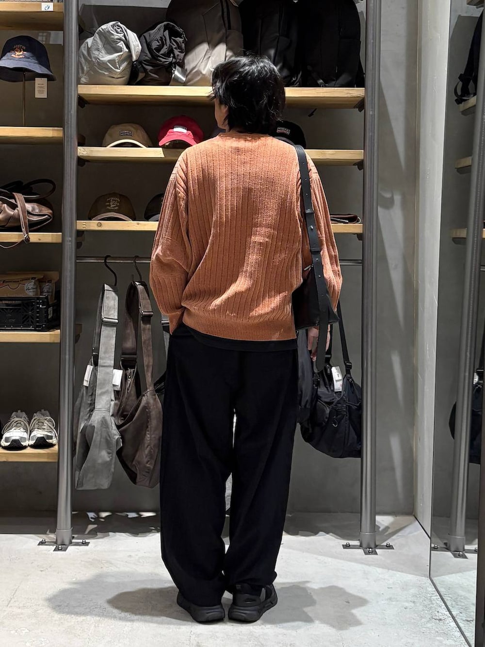 ブラック系のその他パンツ、オレンジ系のニット/セーターを着用したメンズの秋コーディネートの3枚目の写真