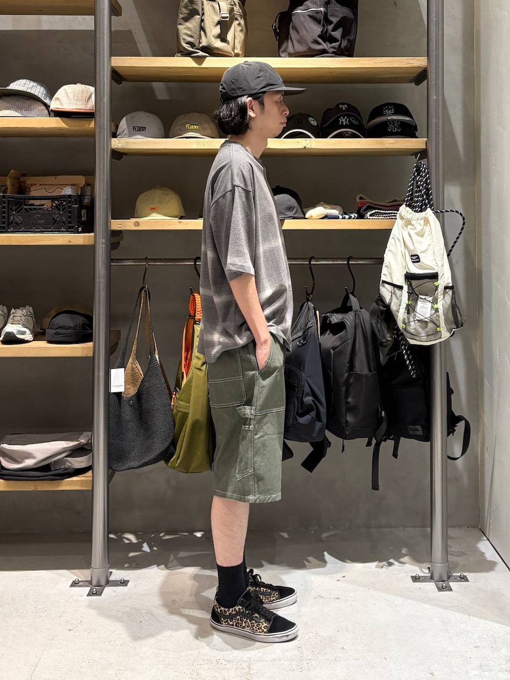 グリーン系のデニムパンツ、グレー系のTシャツ/カットソー、ブラック系のキャップを着用したメンズの夏コーディネートの2枚目の写真