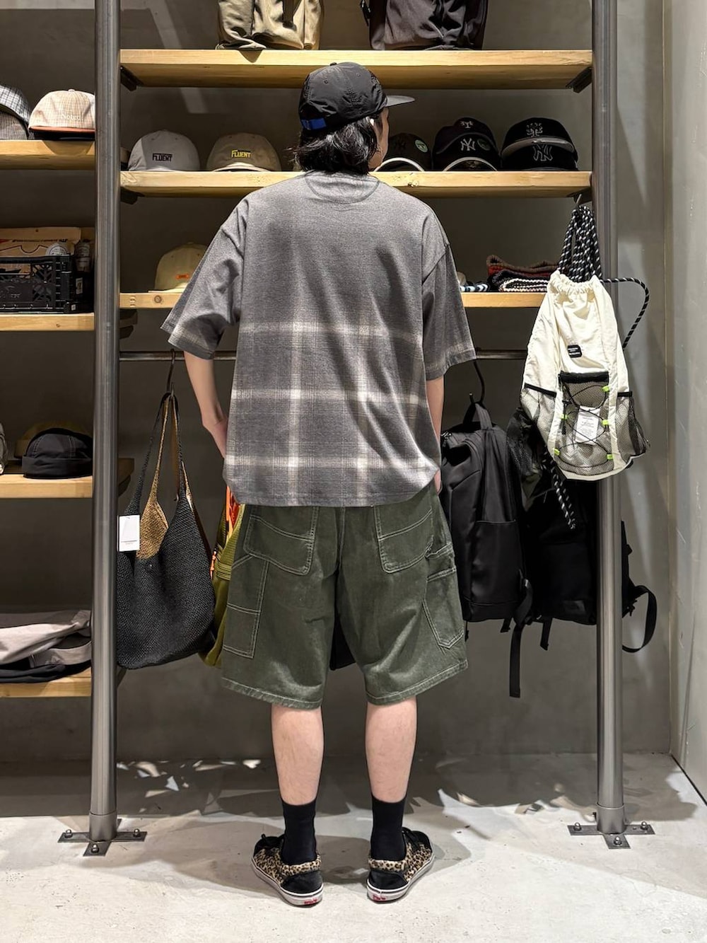 グリーン系のデニムパンツ、グレー系のTシャツ/カットソー、ブラック系のキャップを着用したメンズの夏コーディネートの3枚目の写真