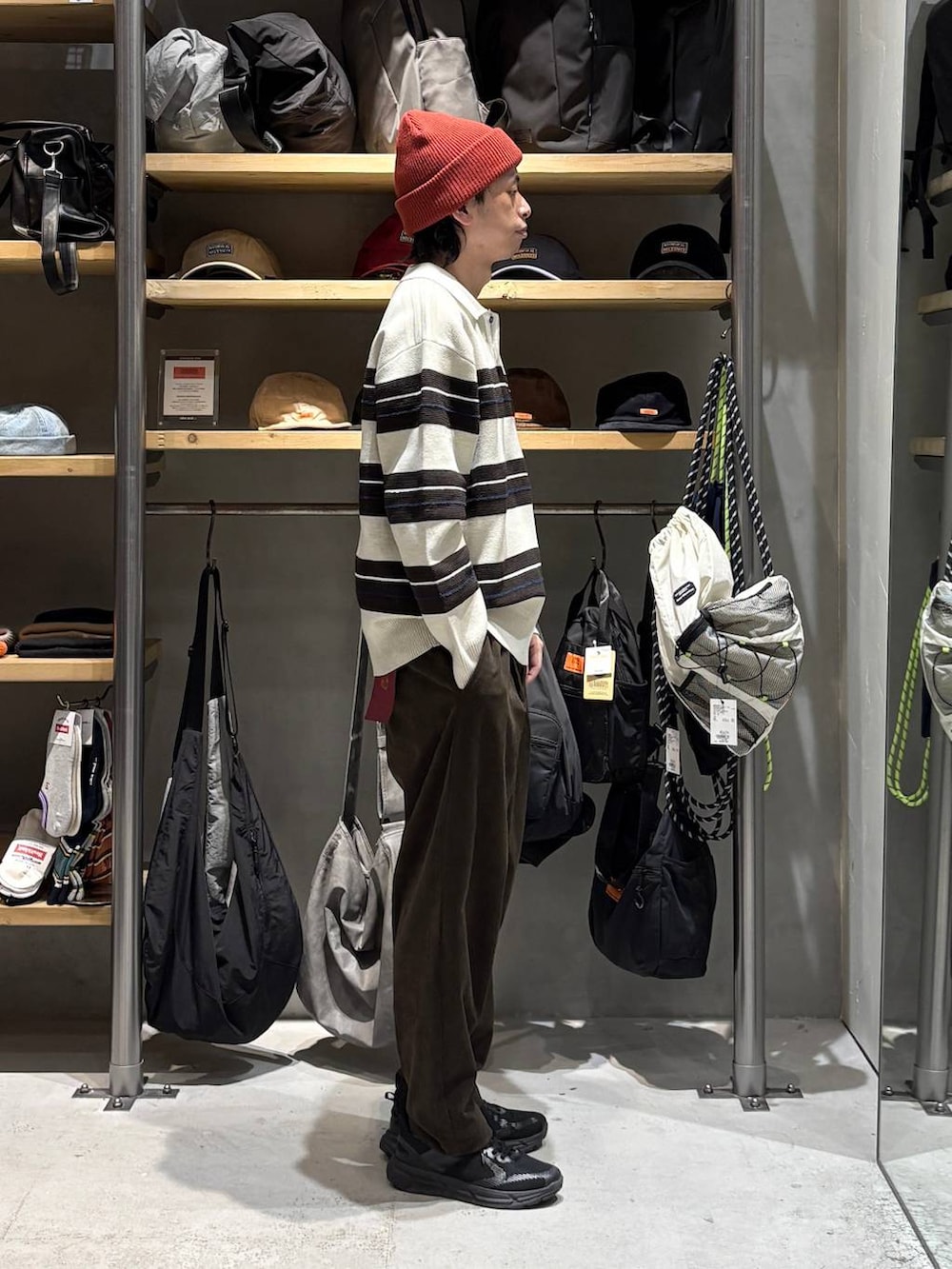 ベージュ系のニット/セーター、ブラウン系のその他パンツ、レッド系のニットキャップ/ビーニーを着用したメンズの秋コーディネートの2枚目の写真