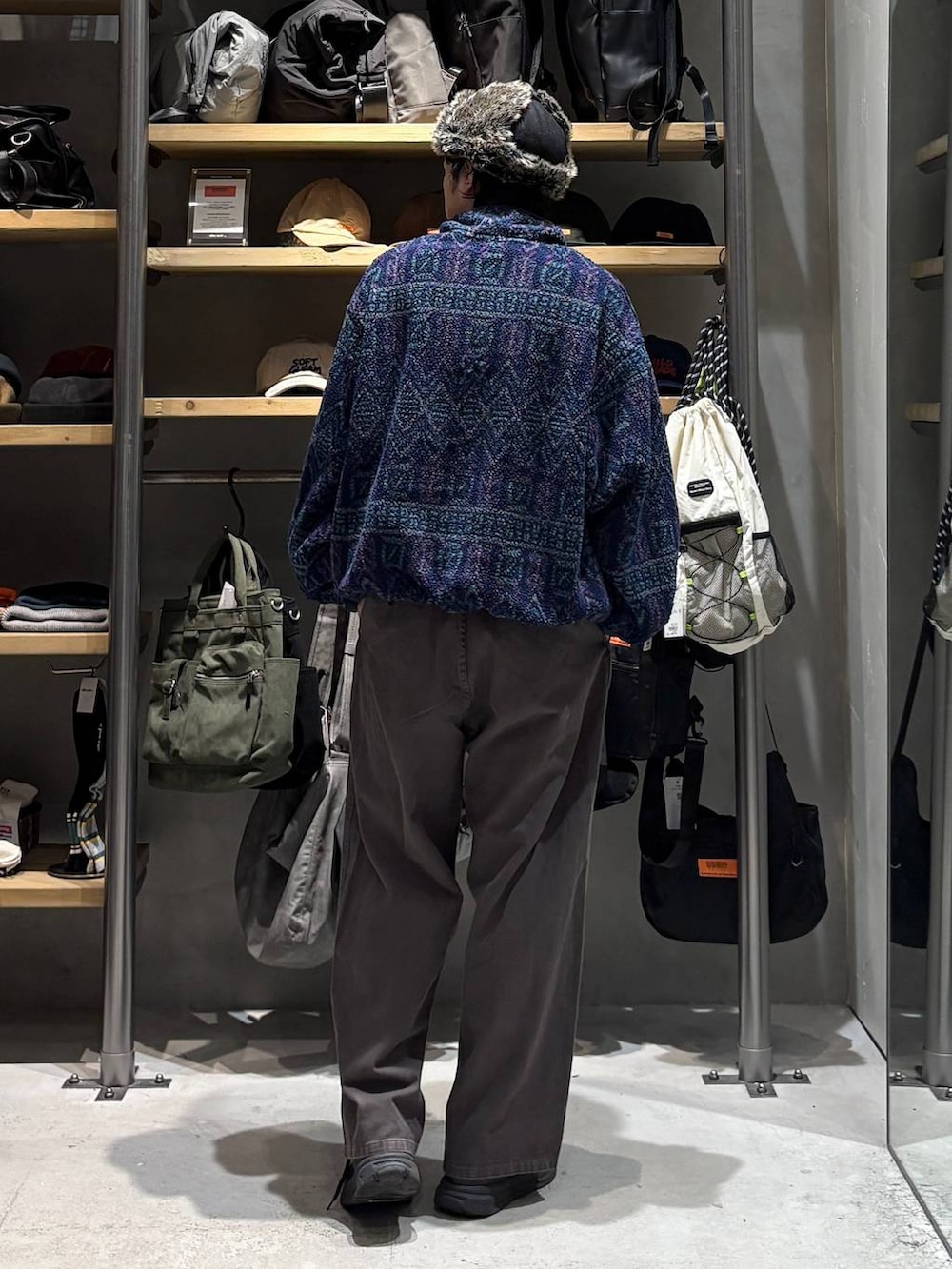 ブラウン系のチノパンツ、ブルー系のその他トップス、ブラック系のキャップを着用したメンズの秋コーディネートの3枚目の写真