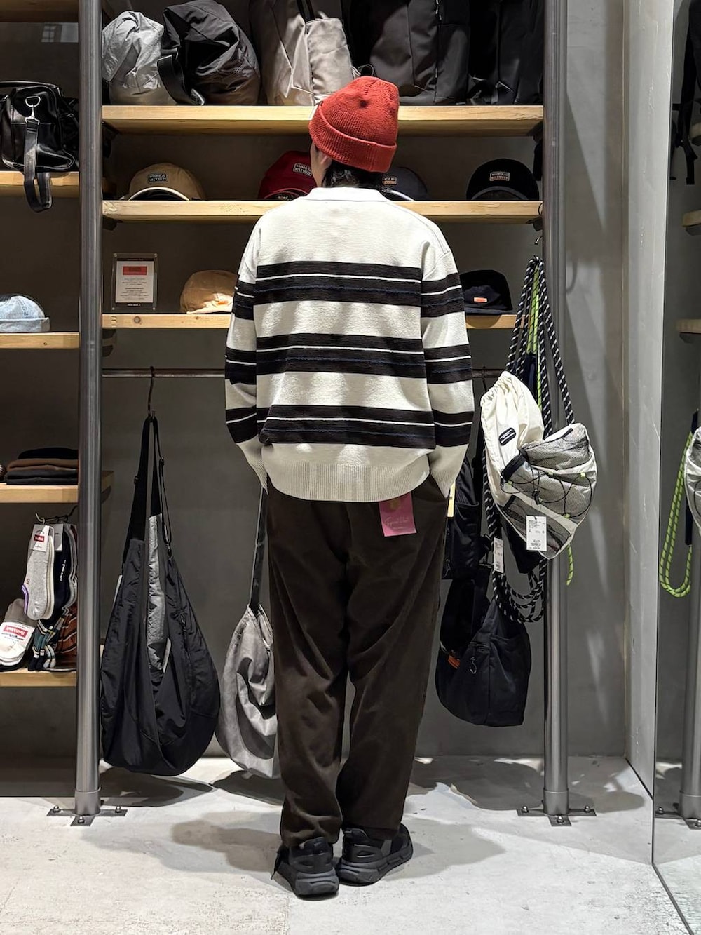 ベージュ系のニット/セーター、ブラウン系のその他パンツ、レッド系のニットキャップ/ビーニーを着用したメンズの秋コーディネートの3枚目の写真