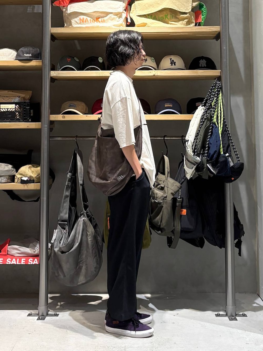 ブラウン系のショルダーバッグ、ホワイト系のTシャツ/カットソー、ブラック系のその他パンツを着用したメンズの夏コーディネートの2枚目の写真