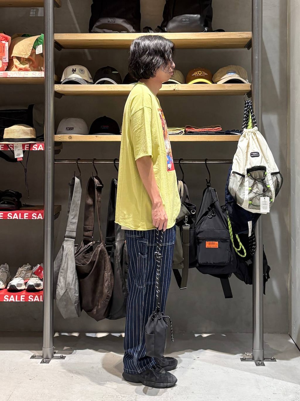 ブラック系のショルダーバッグ、イエロー系のTシャツ/カットソー、その他のデニムパンツを着用したメンズの夏コーディネートの2枚目の写真