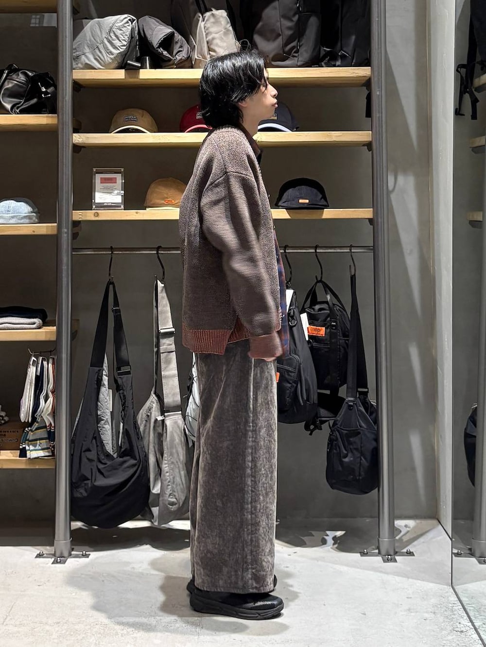 レッド系のシャツ/ブラウス、ブラウン系のカーディガン/ボレロ、グレー系のデニムパンツを着用したメンズの秋コーディネートの2枚目の写真