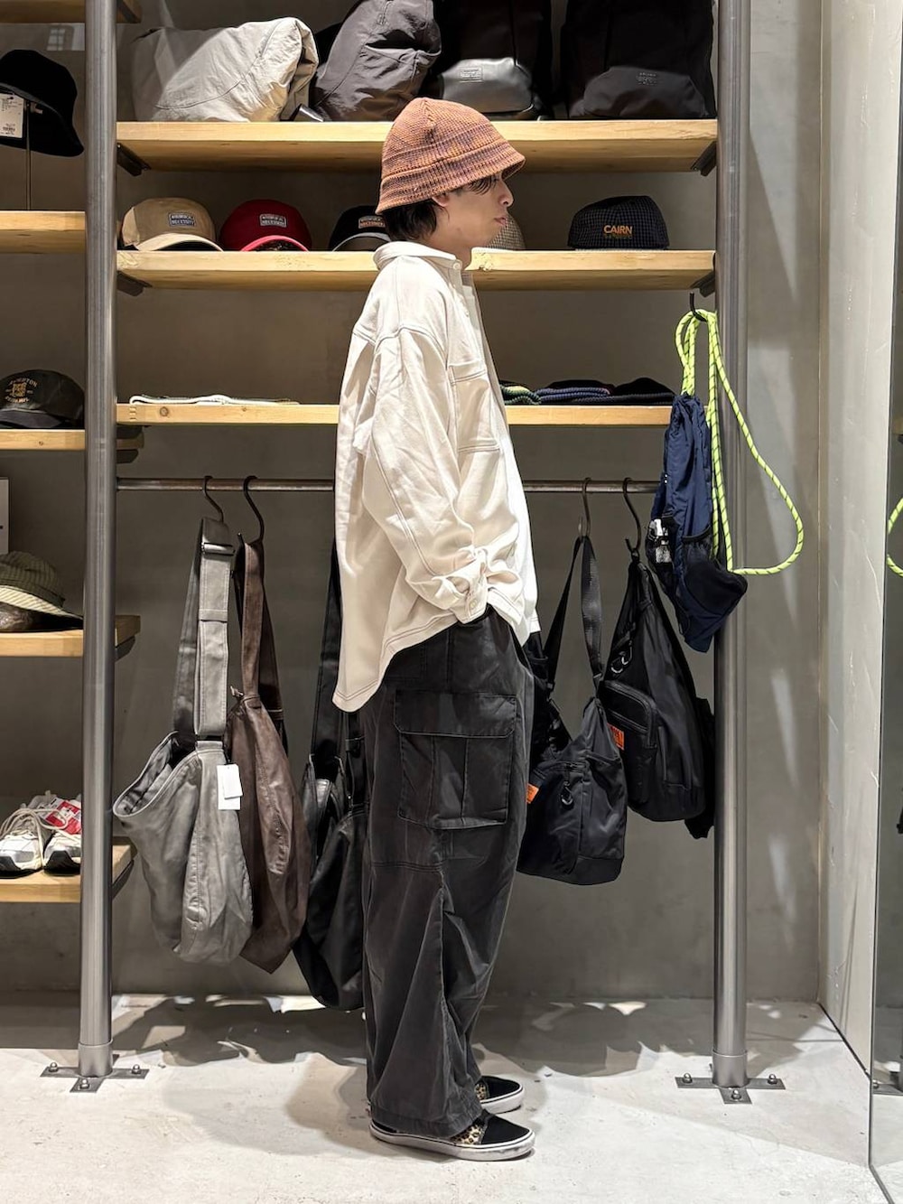 ベージュ系のシャツ/ブラウス、ブラック系のカーゴパンツ、ホワイト系のTシャツ/カットソーを着用したメンズの秋コーディネートの2枚目の写真