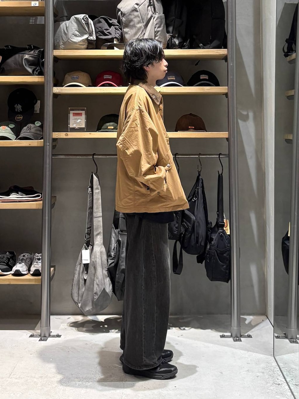 ブラック系のTシャツ/カットソー、イエロー系のブルゾン、グレー系のデニムパンツを着用したメンズの秋コーディネートの2枚目の写真