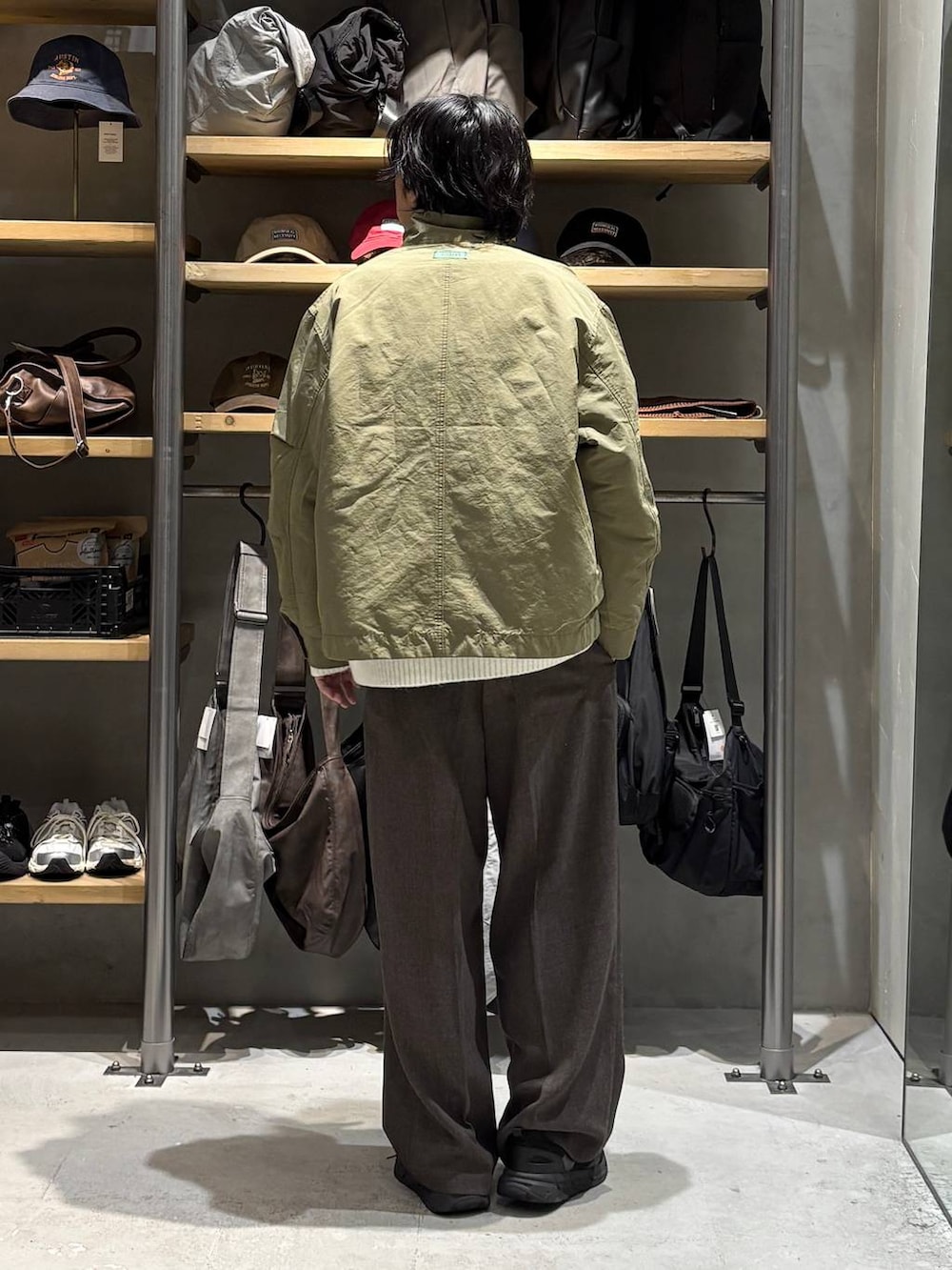 グリーン系のミリタリージャケット、ホワイト系のニット/セーター、ホワイト系のTシャツ/カットソーを着用したメンズの秋コーディネートの3枚目の写真