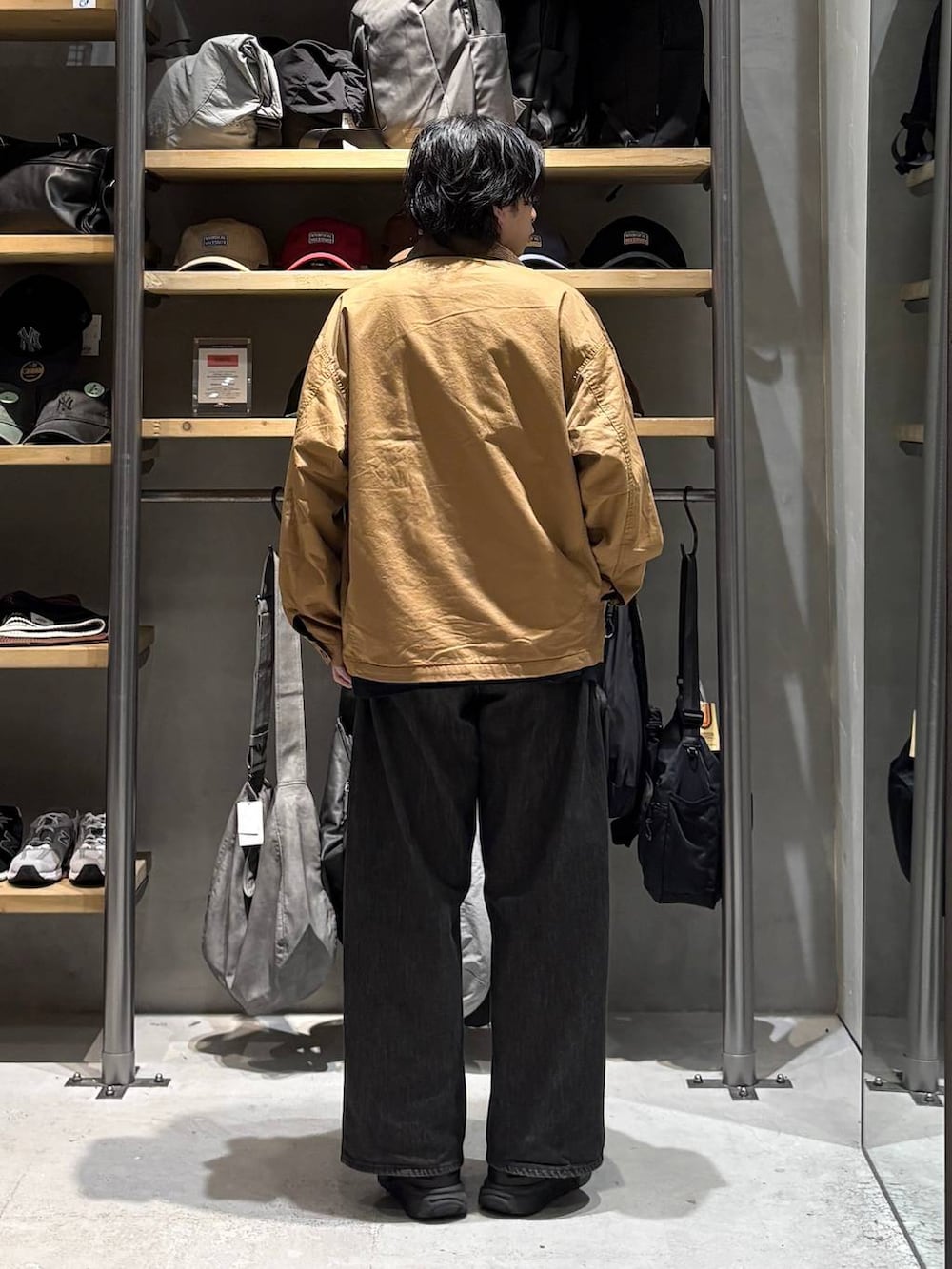 ブラック系のTシャツ/カットソー、イエロー系のブルゾン、グレー系のデニムパンツを着用したメンズの秋コーディネートの3枚目の写真