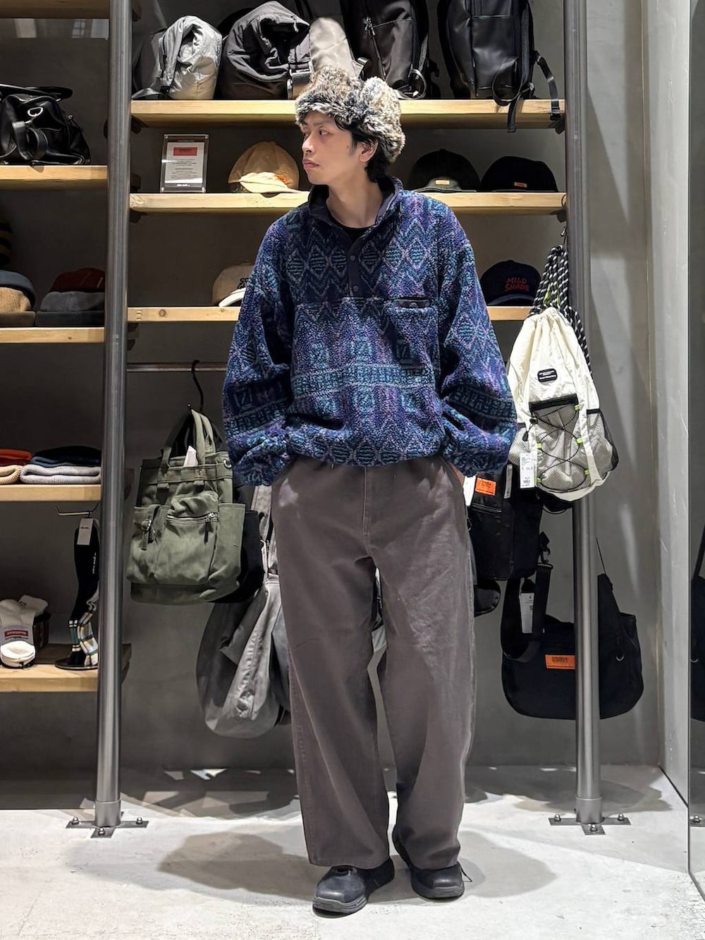 ブラウン系のチノパンツ、ブルー系のその他トップス、ブラック系のキャップを着用したメンズの秋コーディネートの4枚目の写真