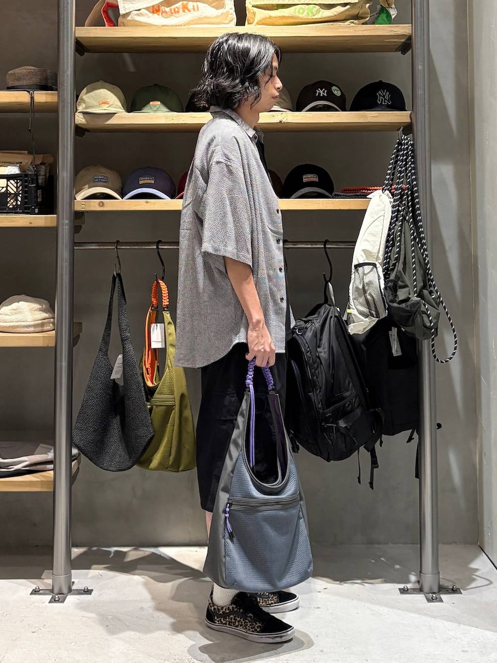 ブラック系のカーゴパンツ、グレー系のトートバッグ、ブラック系のタンクトップを着用したメンズの夏コーディネートの2枚目の写真