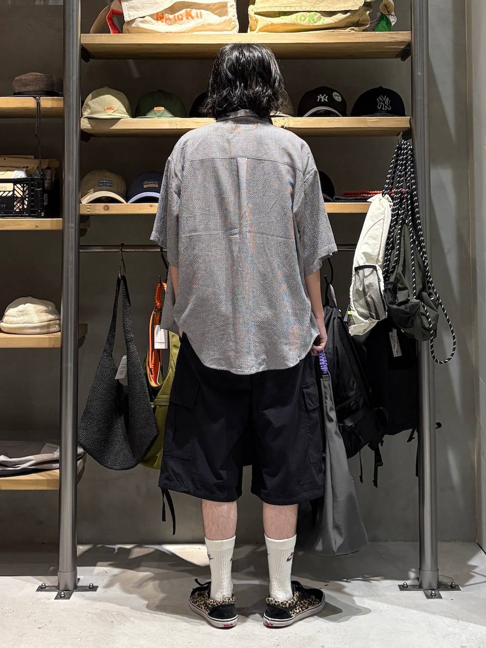 ブラック系のカーゴパンツ、グレー系のトートバッグ、ブラック系のタンクトップを着用したメンズの夏コーディネートの3枚目の写真