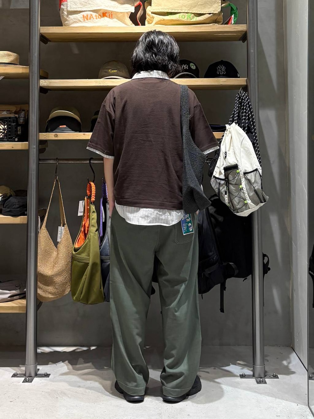 グレー系のトートバッグ、グリーン系のその他パンツ、ブラウン系のポロシャツを着用したメンズの夏コーディネートの3枚目の写真