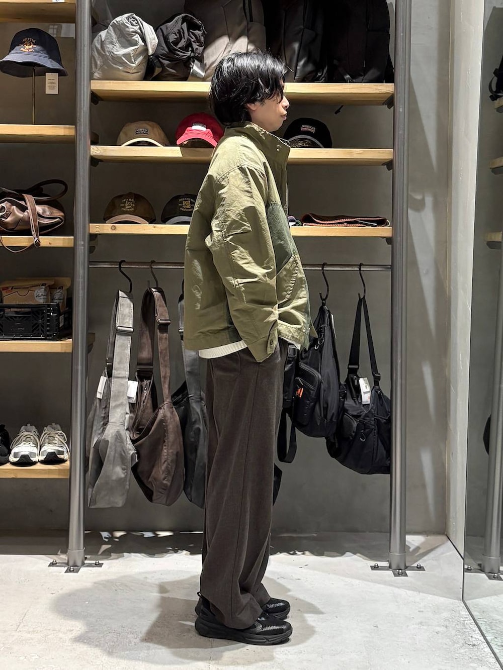 グリーン系のミリタリージャケット、ホワイト系のニット/セーター、ホワイト系のTシャツ/カットソーを着用したメンズの秋コーディネートの2枚目の写真